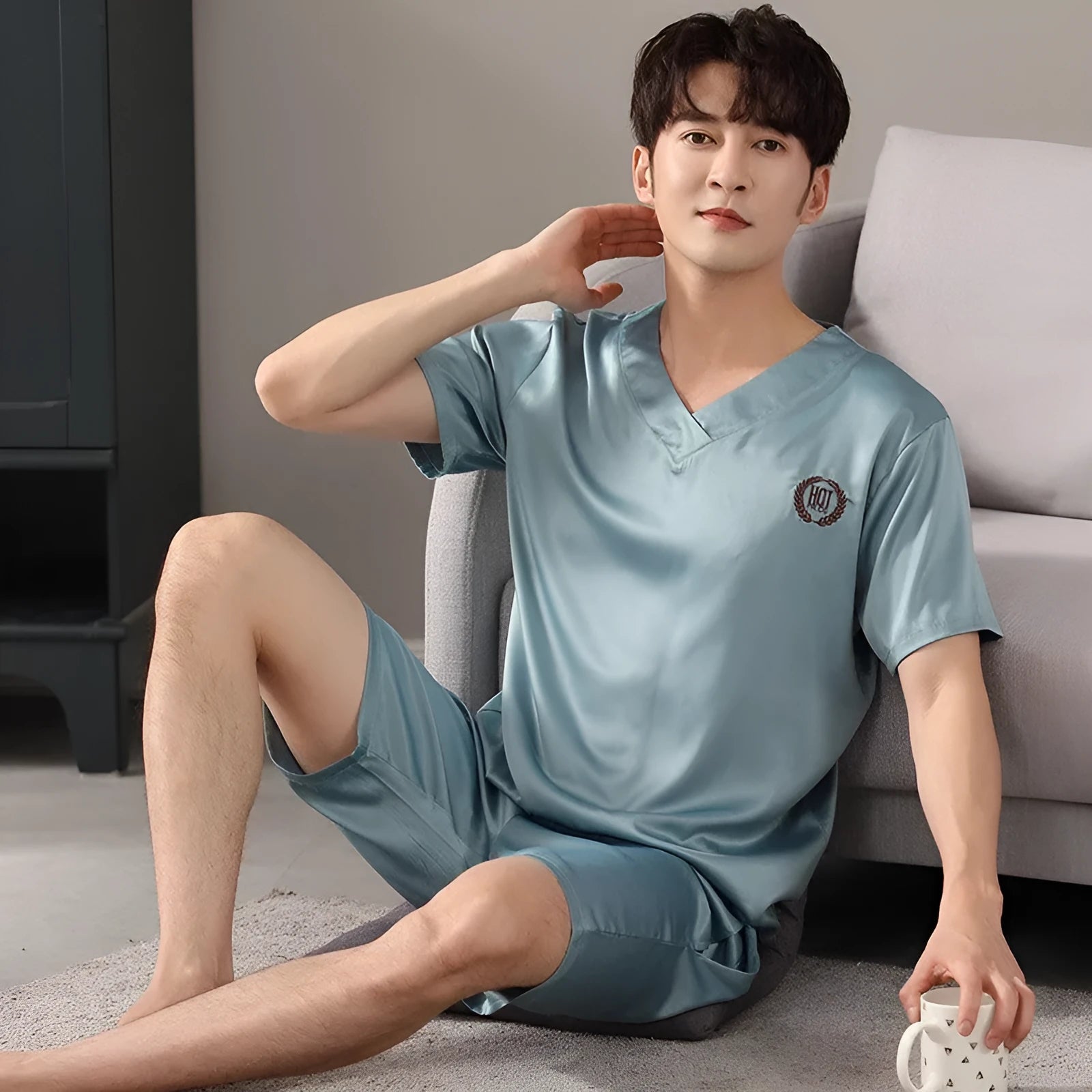 Man wearing a light blue ice silk short-sleeve pajama shirt and matching loose shorts.