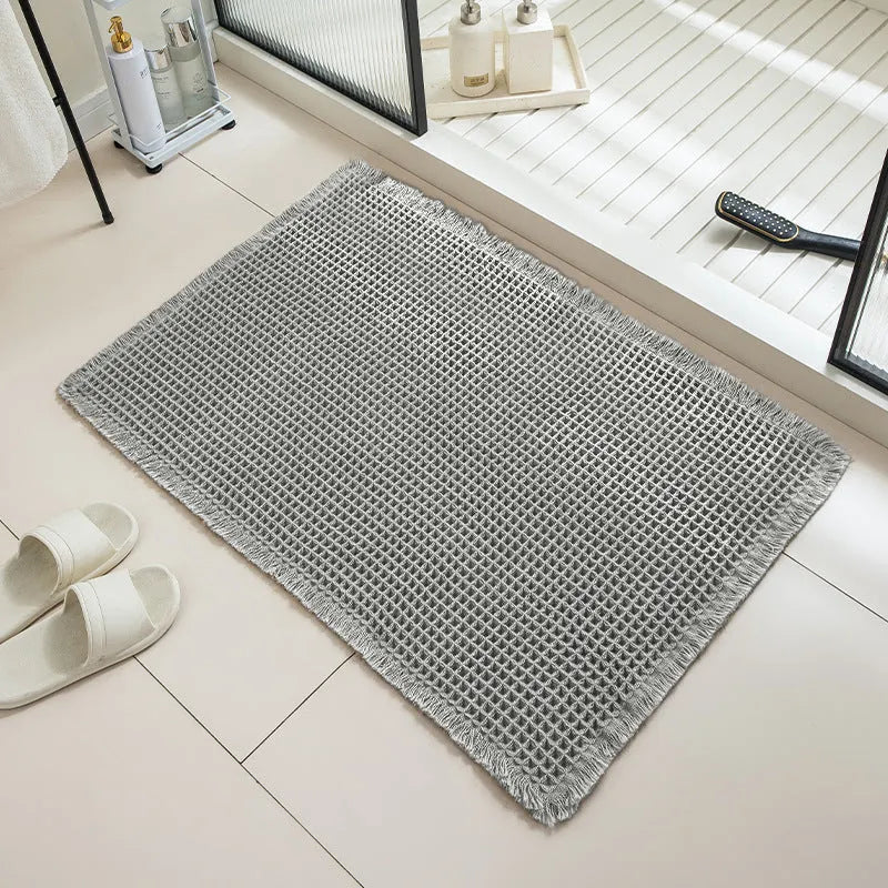 A square, checkered-pattern bathroom carpet in a choice of colours on a tiled floor.