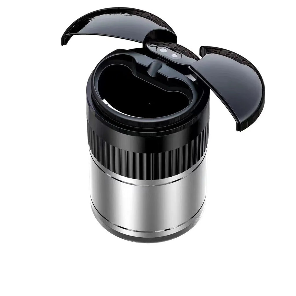 Smart black metal car ashtray with lid, showing compact size next to a charging cable.