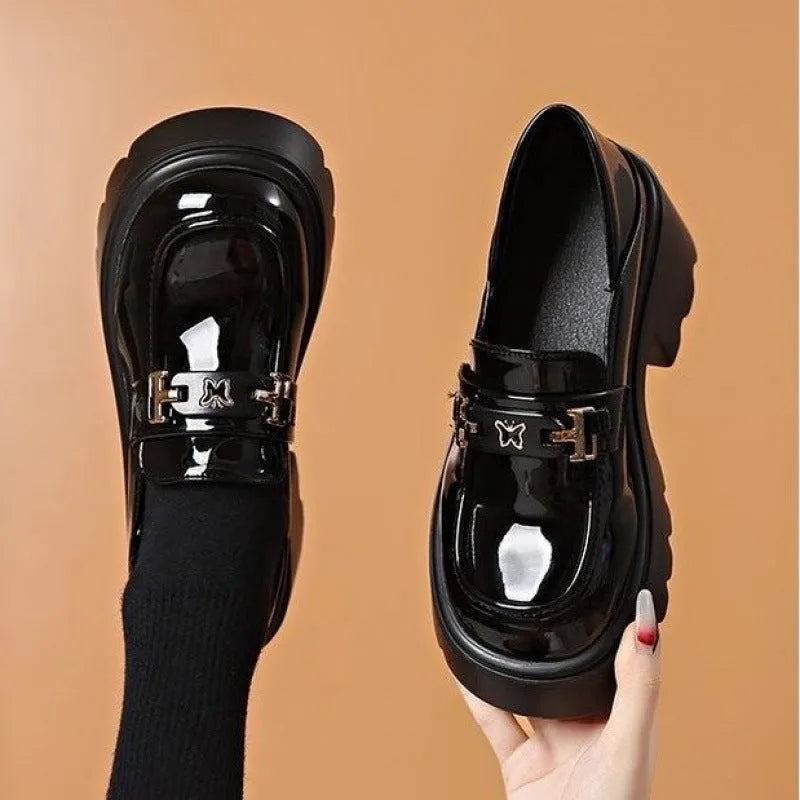 Slip-on chunky heel black leather shoes with skull pattern and square heel on a white background