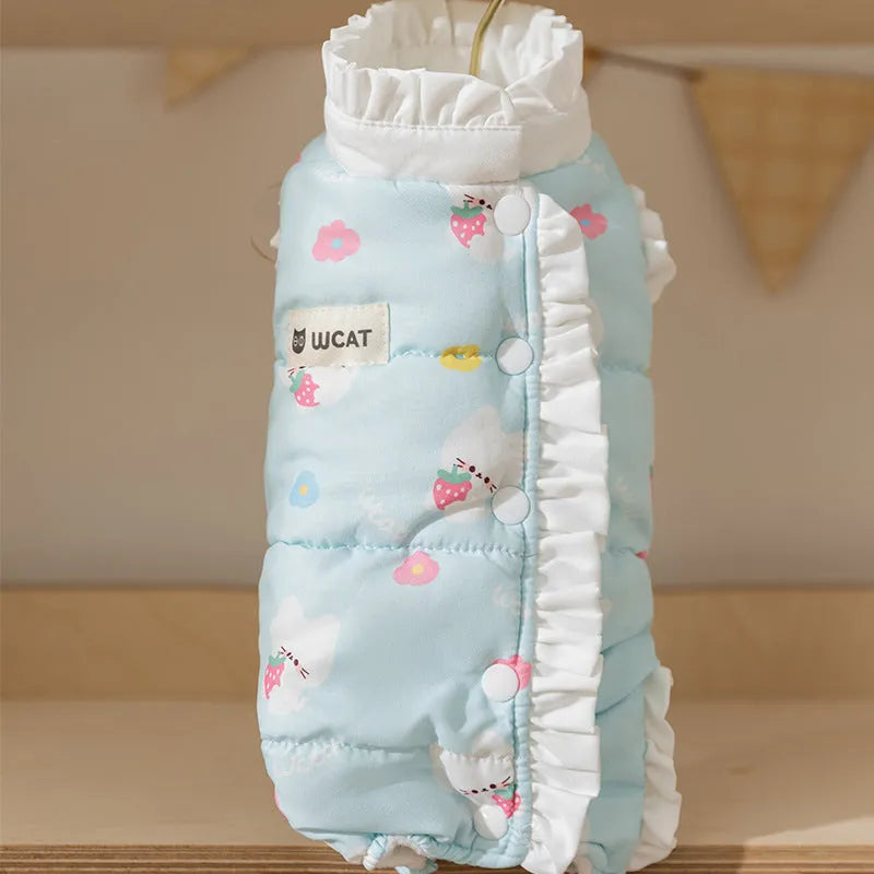 Small dog wearing cream fleece jumpsuit with bear pattern and white ruffles