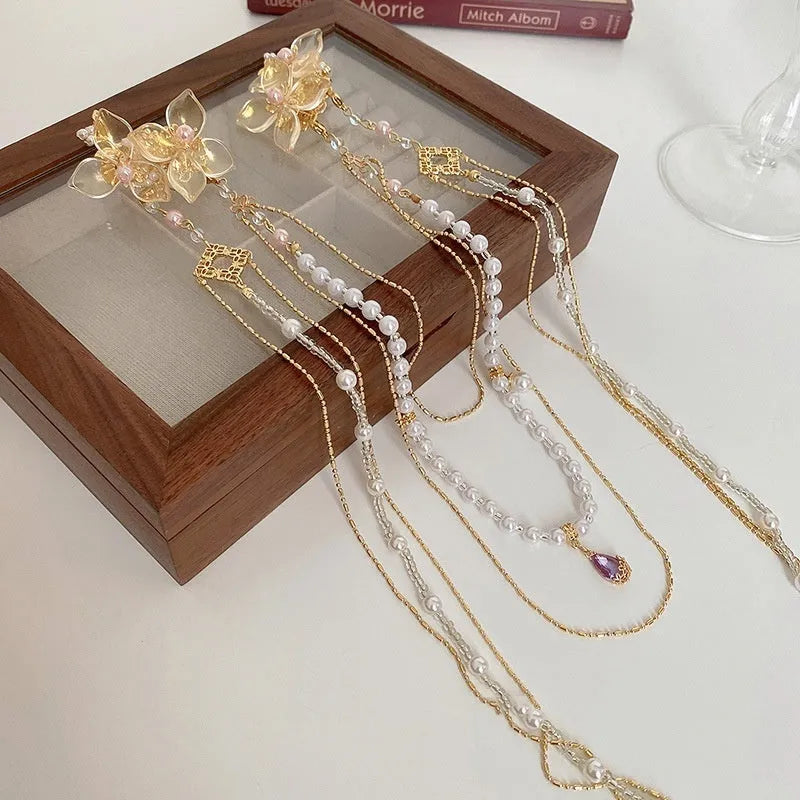 Gold acrylic women's hairpin with flower shape, pearl diamond details, and long tassel design