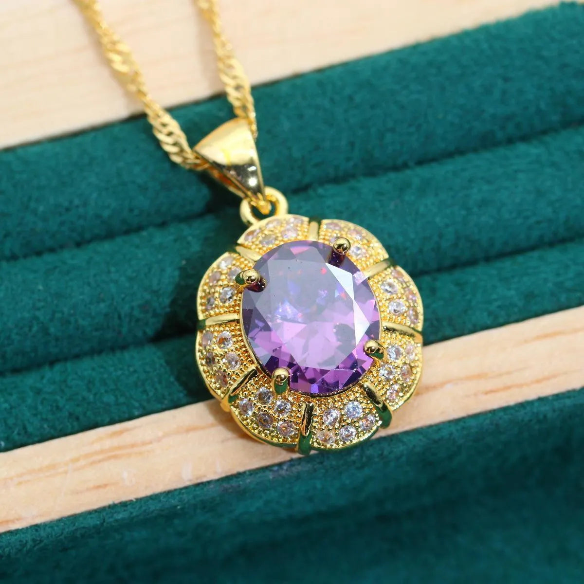 Gold plated cubic zirconia jewellery set with necklace, earrings, ring, and bracelet in blue, green, purple, or red.