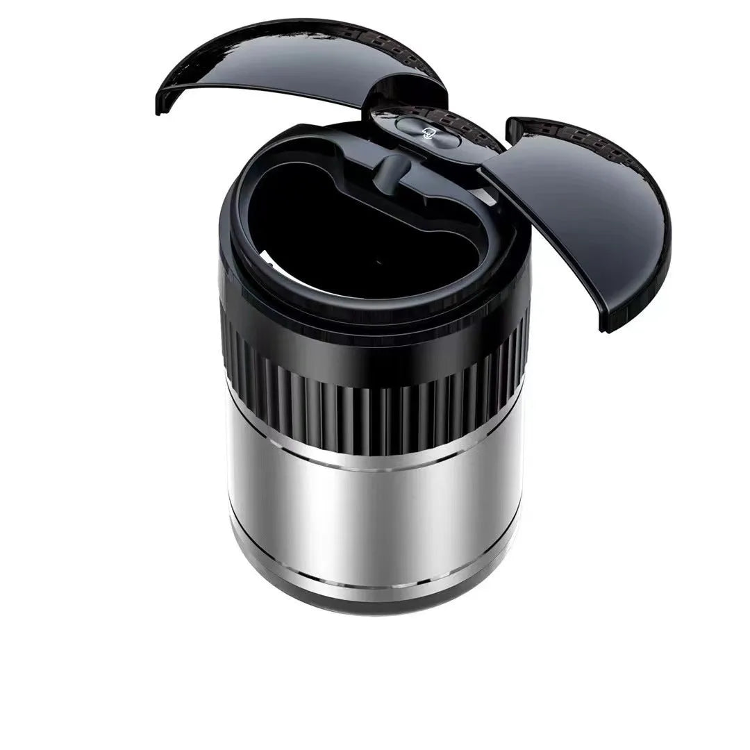 Smart black metal car ashtray with lid, showing compact size next to a charging cable.