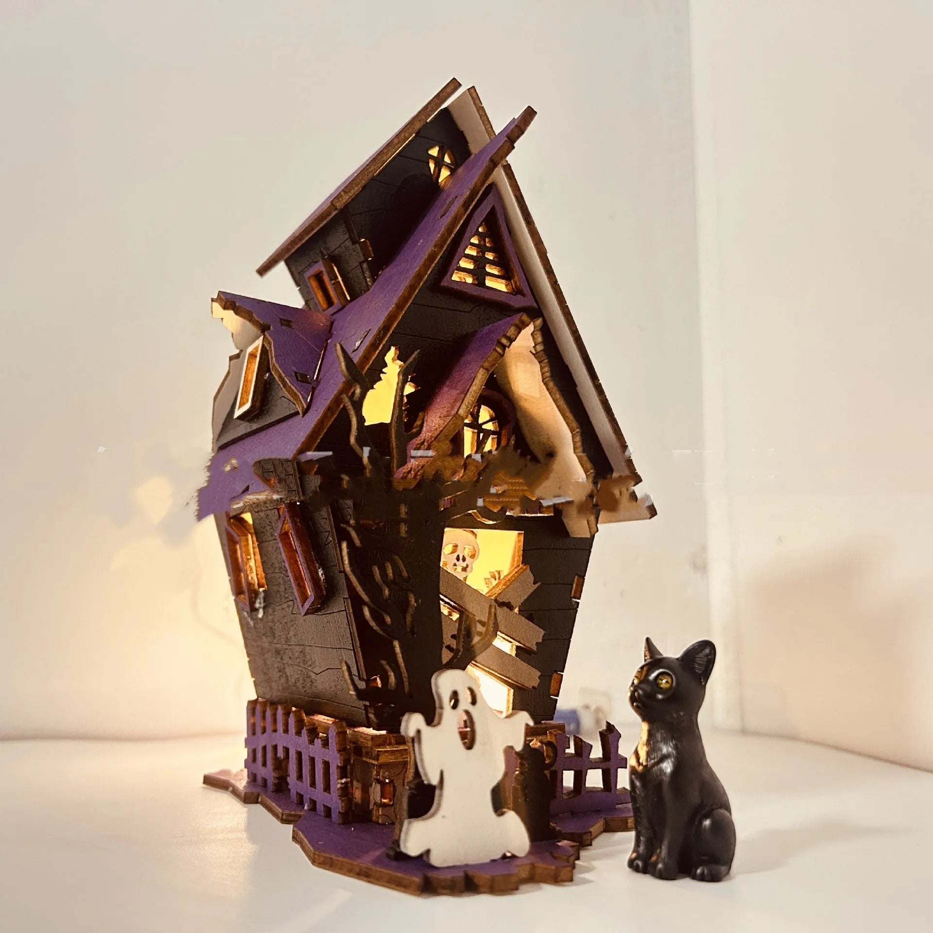 Wooden glowing haunted house Halloween table decoration with candlestick holder, 14cm wide.