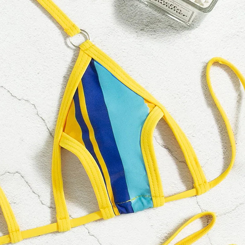 Yellow women's halter neck bikini with backless design and high-waist shorts on a neutral background.