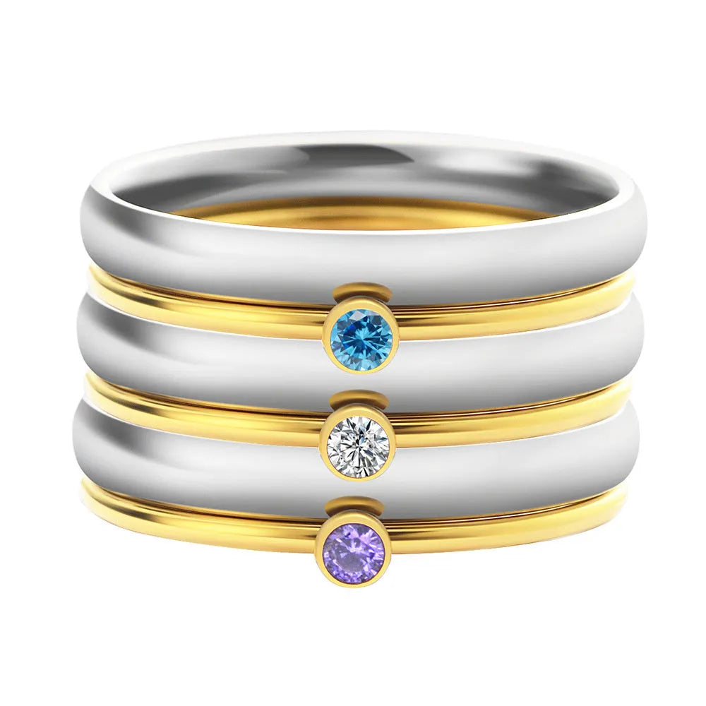 Geometric titanium steel ring with a raised December colour birthstone setting on a gold-toned band.