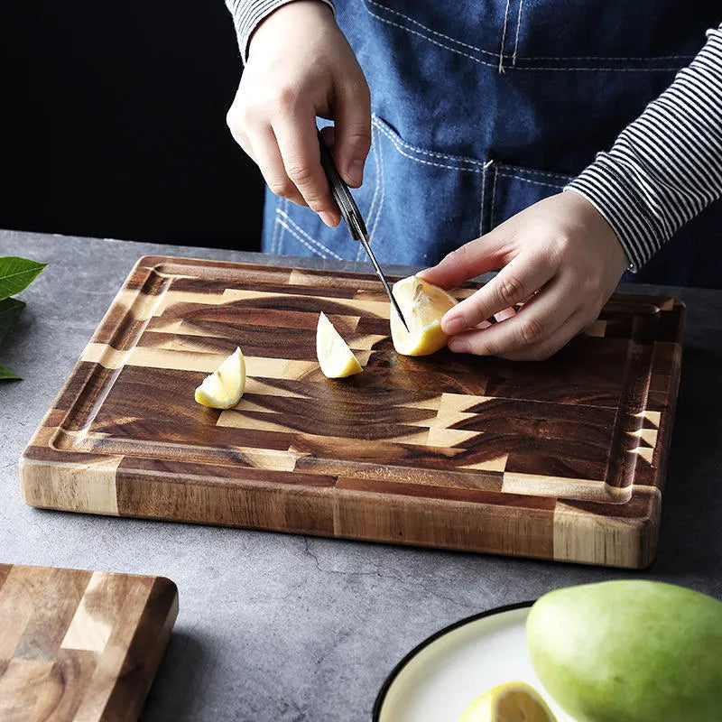 Brown parquet pattern solid acacia wood chopping board on a kitchen counter.