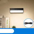 Compact white magnetic LED desk lamp with touch dimming on a wooden desk.