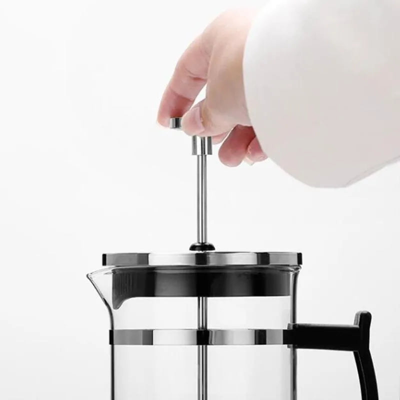 Compact pour-over coffee maker with glass carafe and stainless steel filter holder