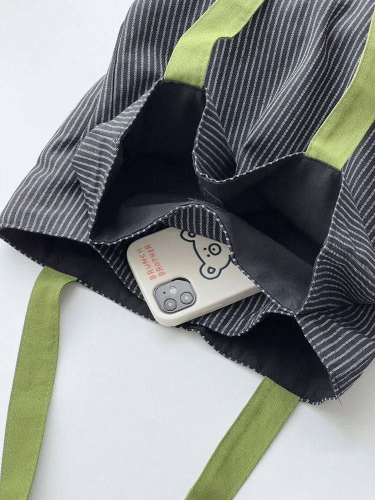 Casual multi-layer canvas tote shoulder bag in a plaid pattern with a wide strap.