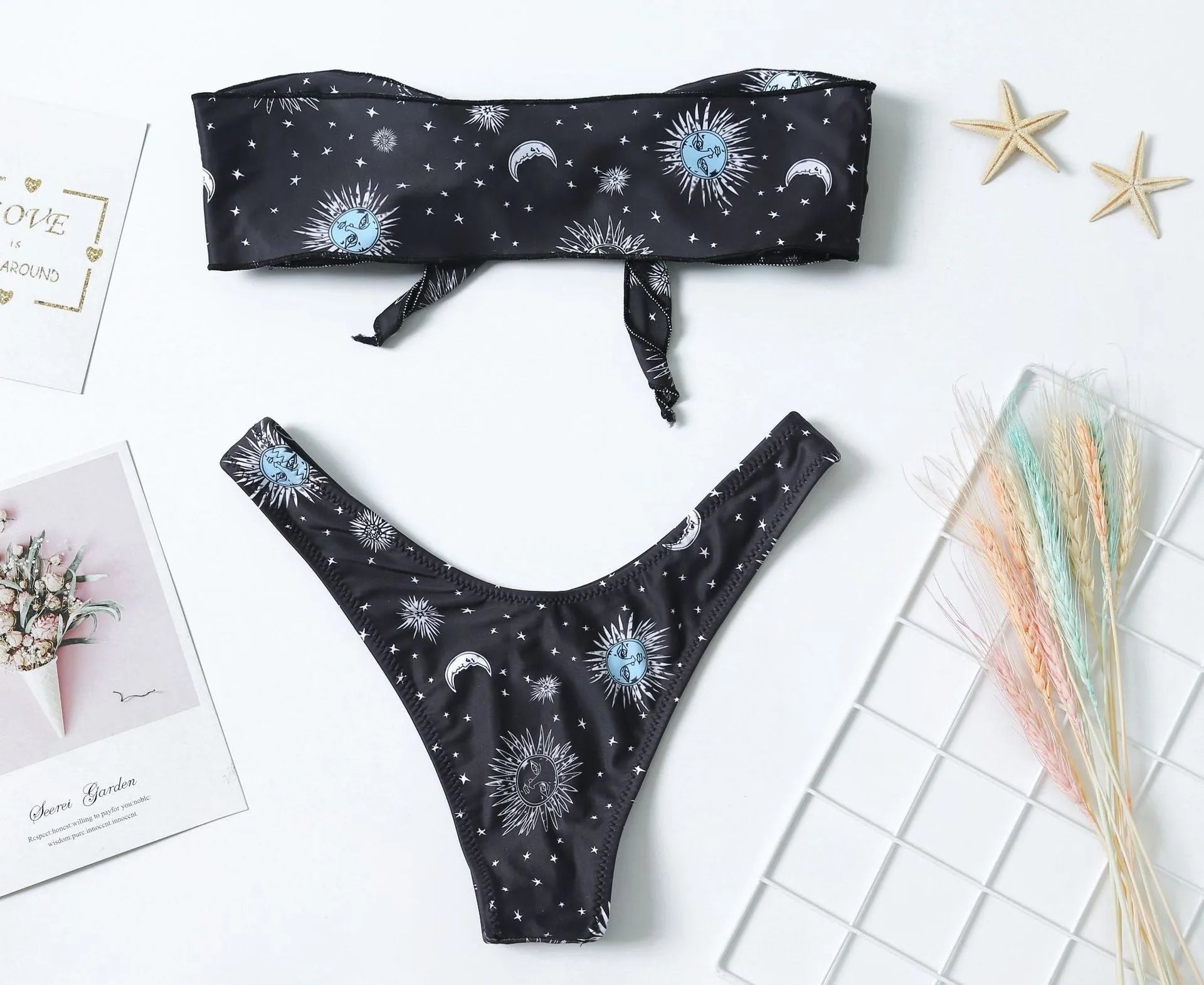 Black one-piece swimsuit with bikini print pattern and split tube top design.