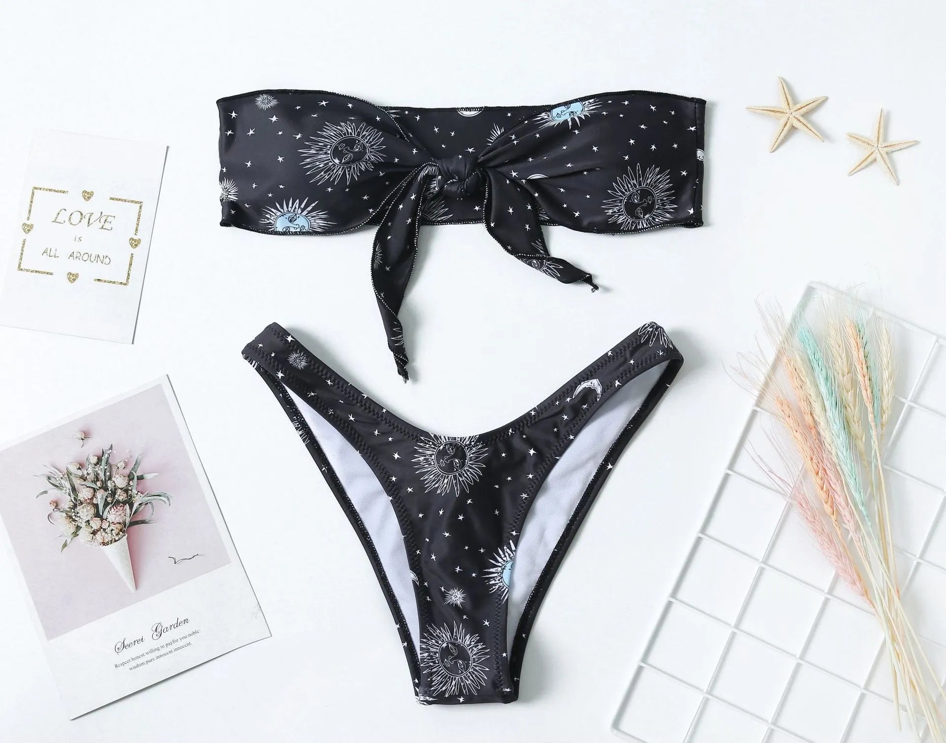 Black one-piece swimsuit with bikini print pattern and split tube top design.
