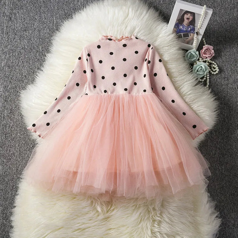 Baby girl wearing a long sleeve white lace tutu dress for a christening or birthday party.