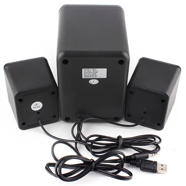 Green 2.1 USB computer speaker with colourful LED lights, showing USB and audio jack ports on a desktop.