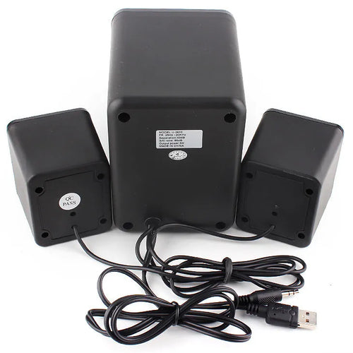 Green 2.1 USB computer speaker with colourful LED lights, showing USB and audio jack ports on a desktop.