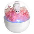 Pink rabbit-shaped aromatherapy humidifier with preserved flower decoration on bedside table