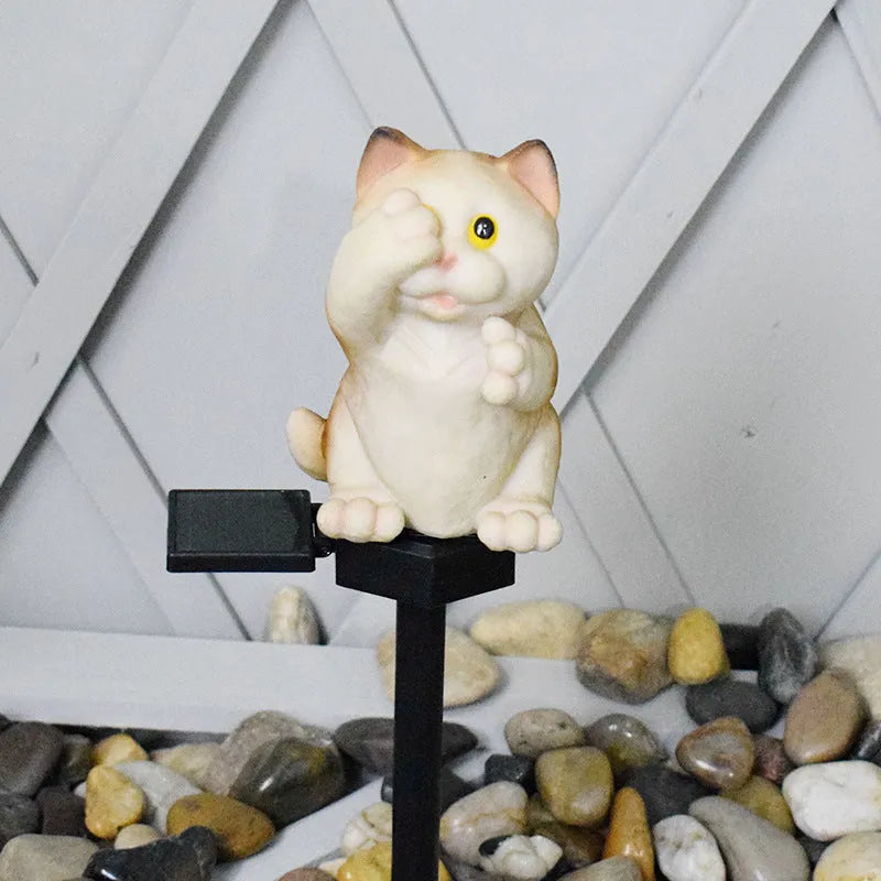 Brown cat-shaped solar lawn light in garden setting with LED illumination at dusk