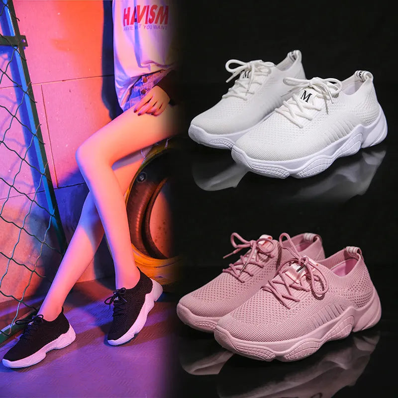 Women's white fly knit slip-on sport shoes with a thick rubber sole and front strap.