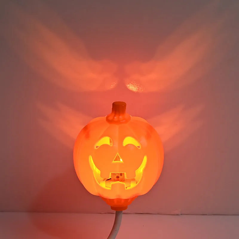A plastic pumpkin lamp with a USB port, glowing in either yellow or purple light.