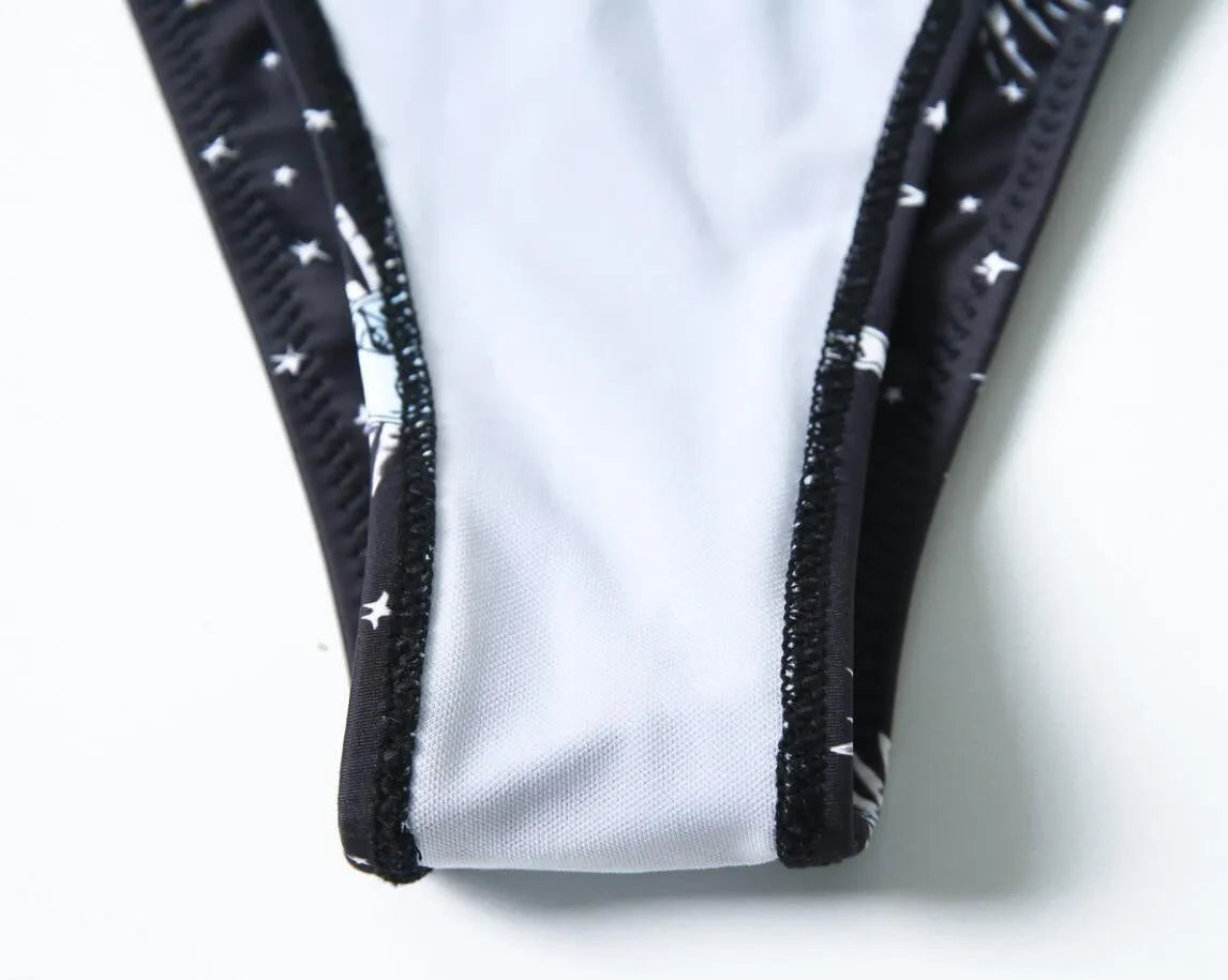 Black one-piece swimsuit with bikini print pattern and split tube top design.