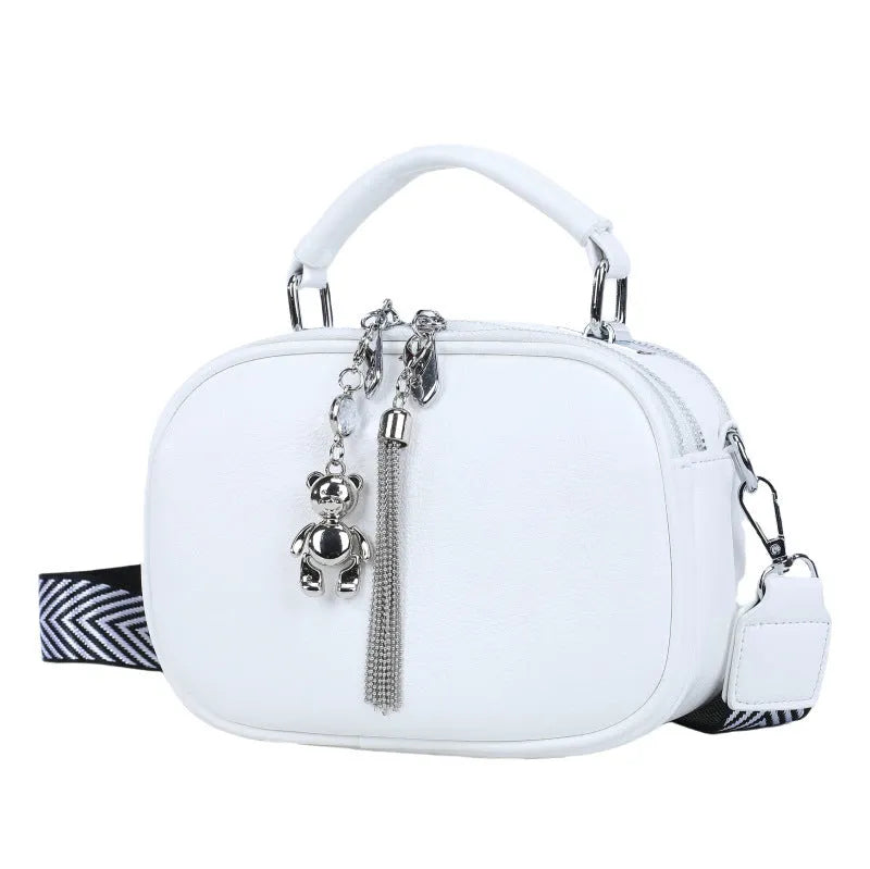 Women's small oval crossbody bag in PU with stitching detail and double straps, shown in multiple colours.