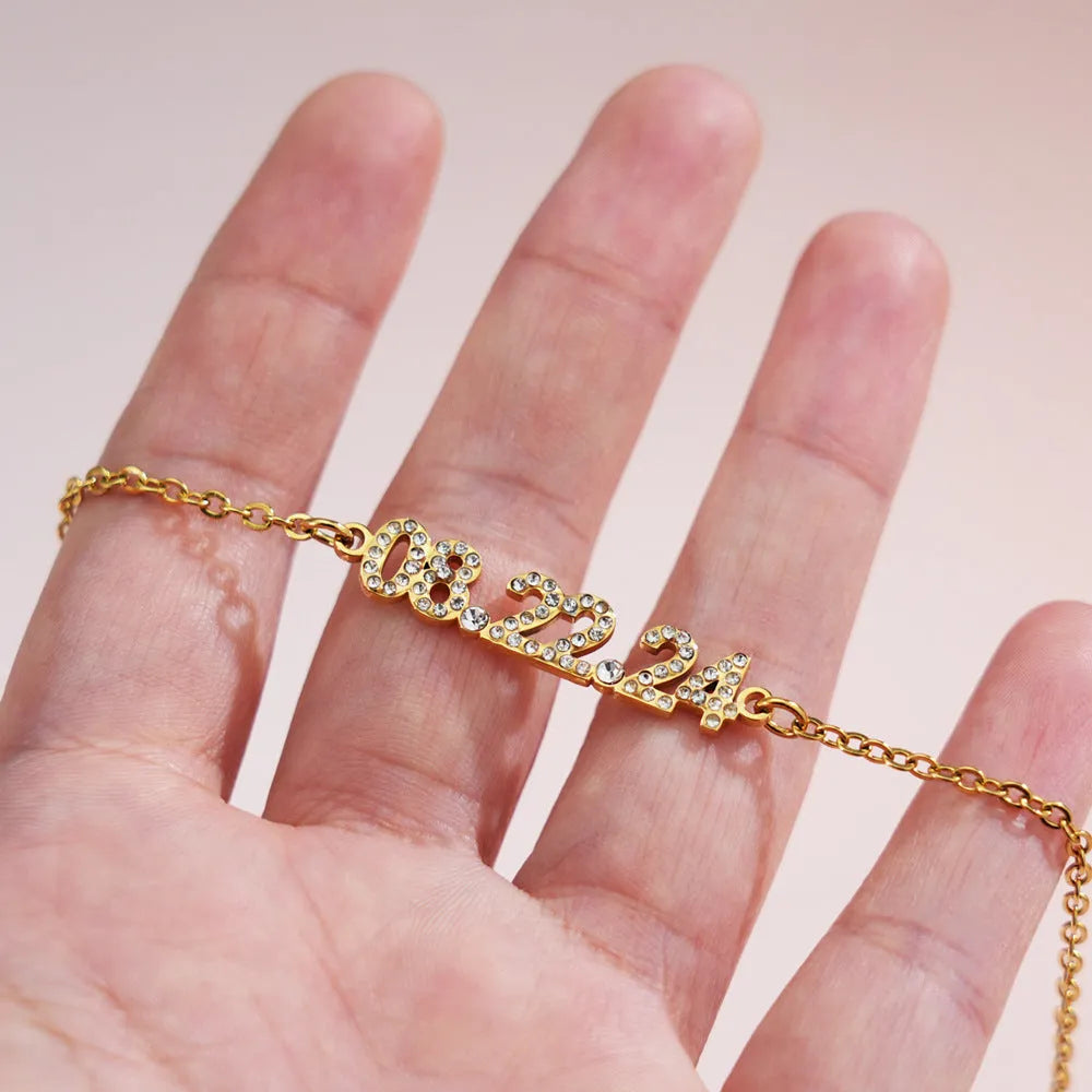 Stainless steel digital bracelet and necklace with diamond-set numbers in gold, rose gold, or steel colour.