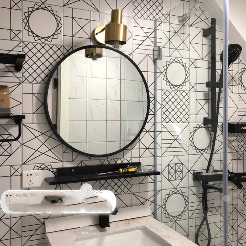 Round metal wall mirror in black finish, shown on a bathroom wall.