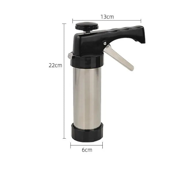Stainless steel biscuit press gun with assorted cookie moulds and icing nozzles on a baking sheet.