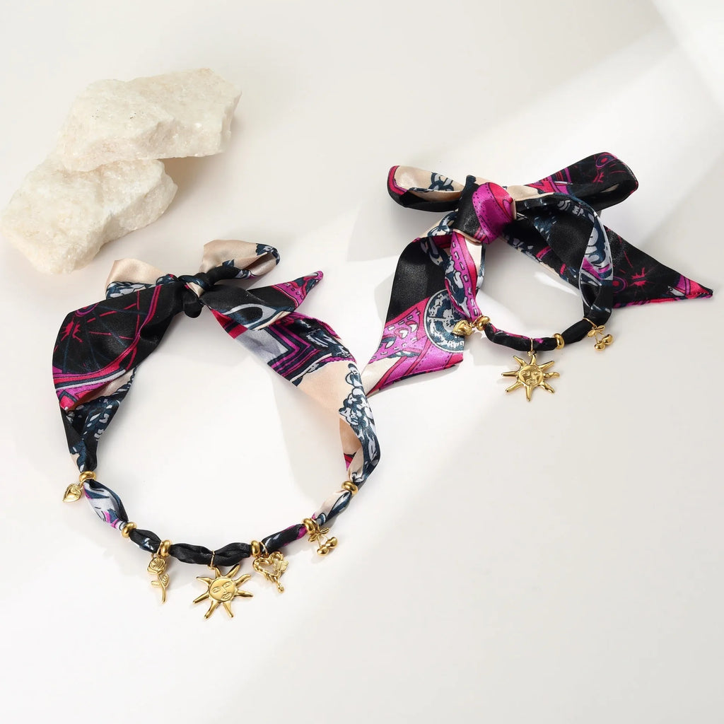 Geometric pendant on a gold chain, shown as a women's necklace or bracelet against an autumn backdrop.