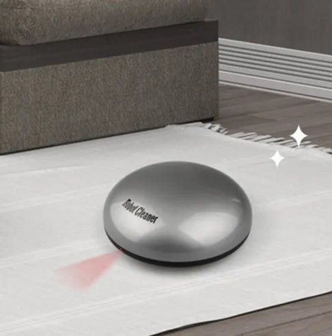 Silver-coloured compact automatic sweeping robot vacuum cleaner on a wooden floor.