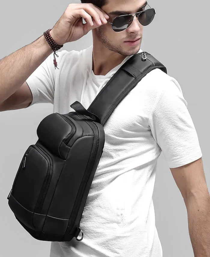 Black PVC medium-sized shoulder bag with air cushion strap and soft handle.