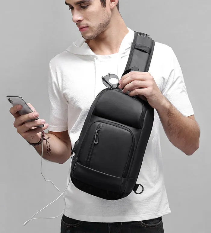 Black PVC medium-sized shoulder bag with air cushion strap and soft handle.