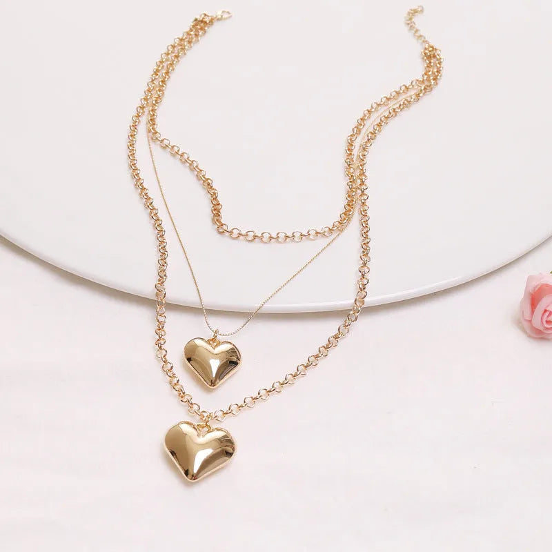 Gold multi-layer heart pendant necklace for women with alloy construction and electroplated finish.