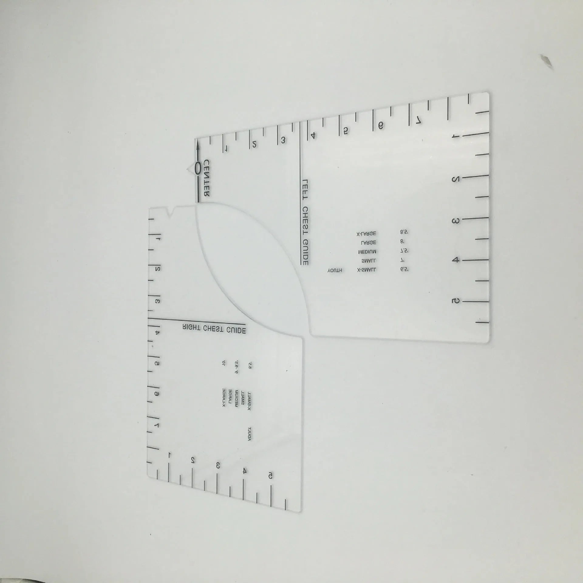 Transparent acrylic sewing ruler for aligning T-shirt designs, measuring 10 by 6 inches.