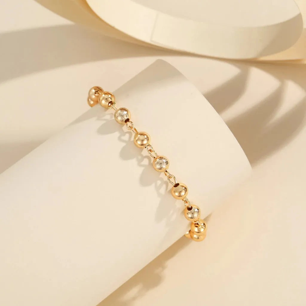 Gold electroplated copper unisex retro beaded bracelet on a neutral background