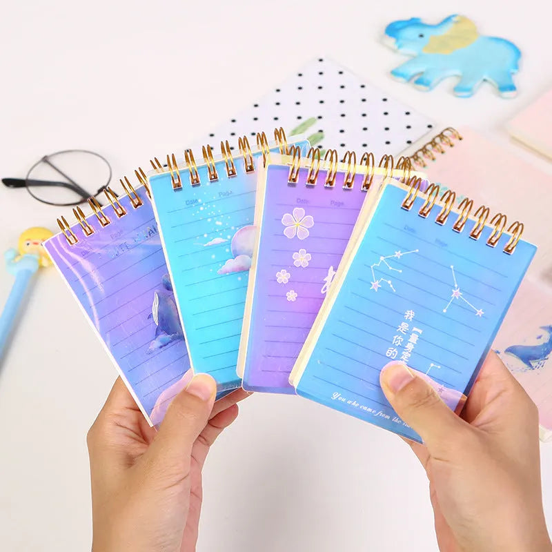 A7 rollover coil spiral notebook in four colours with spiral binding showing lay-flat pages