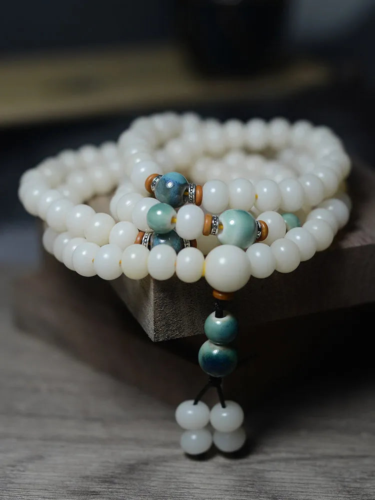 White jade bodhi seed bracelet with 108 flat round beads in two sizes on wrist
