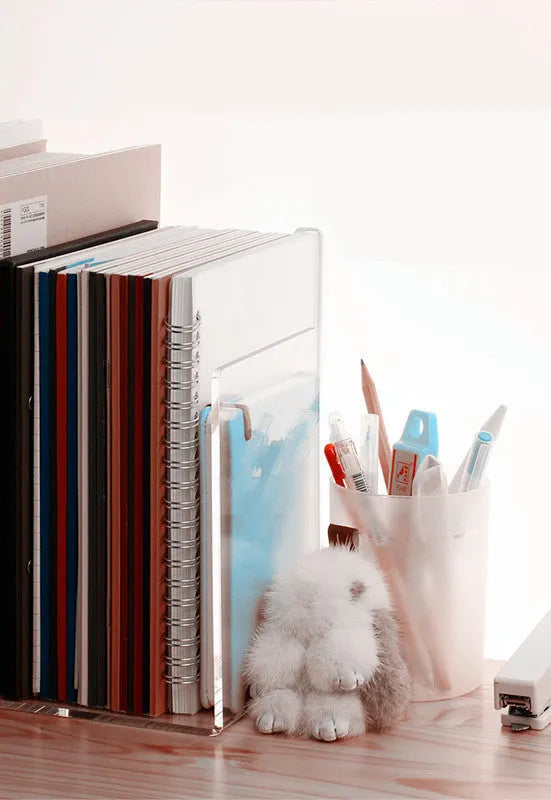 Transparent acrylic bookcase displaying textbooks on smooth-edged plexiglass shelf