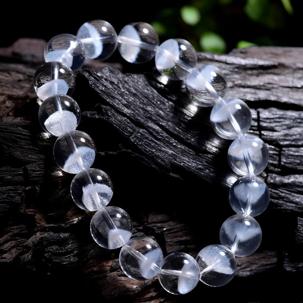 Women's white crystal pyramid bracelet with Ruyi symbols on wrist, showing ground bead texture.