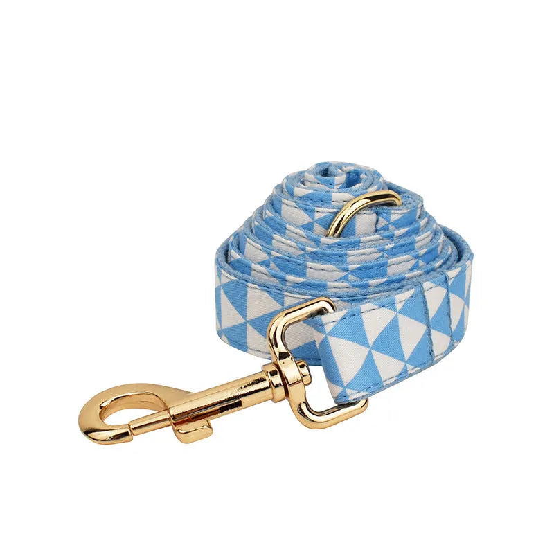 Blue cloth dog vest set with matching collar, lead, and decorative bow on a triangular ring.