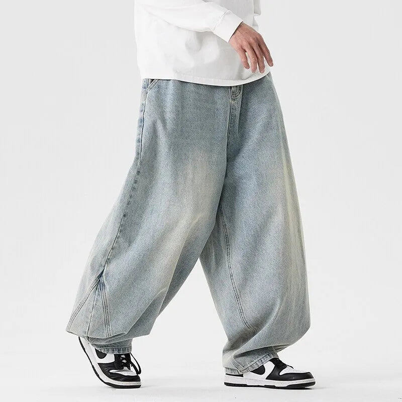 Men's plus-size baggy blue denim jeans with straight leg and low waist on a neutral background.