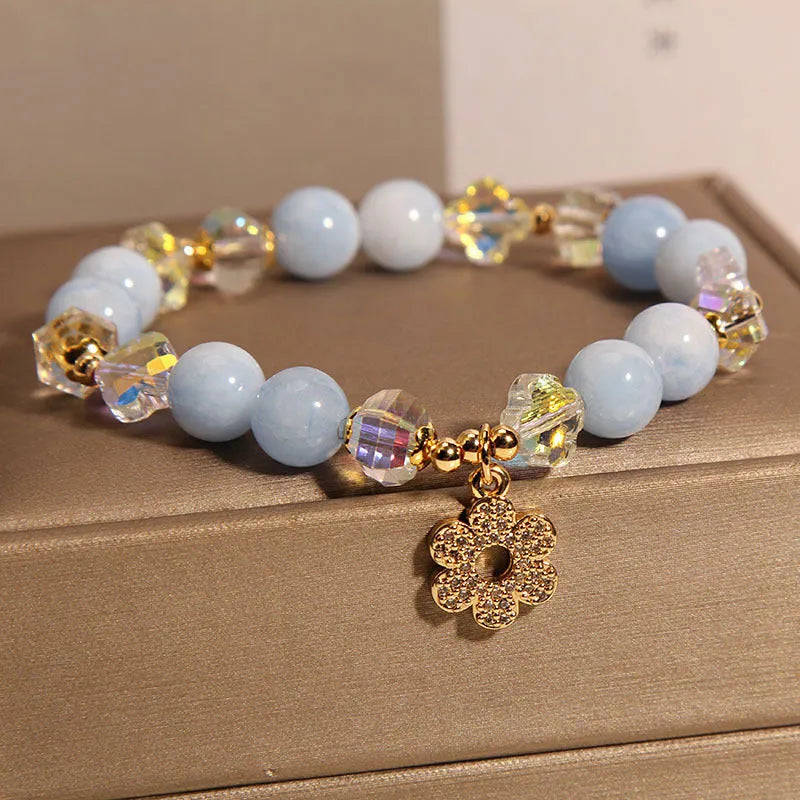 Women's aquamarine crystal bracelet with four-leaf clover charm and pearl accent on a chain