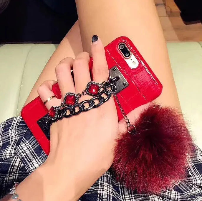 PU leather iPhone case with fox fur ball and rhinestone studs, compatible with iPhone 6, 6s, 7, 8, Plus, and X.