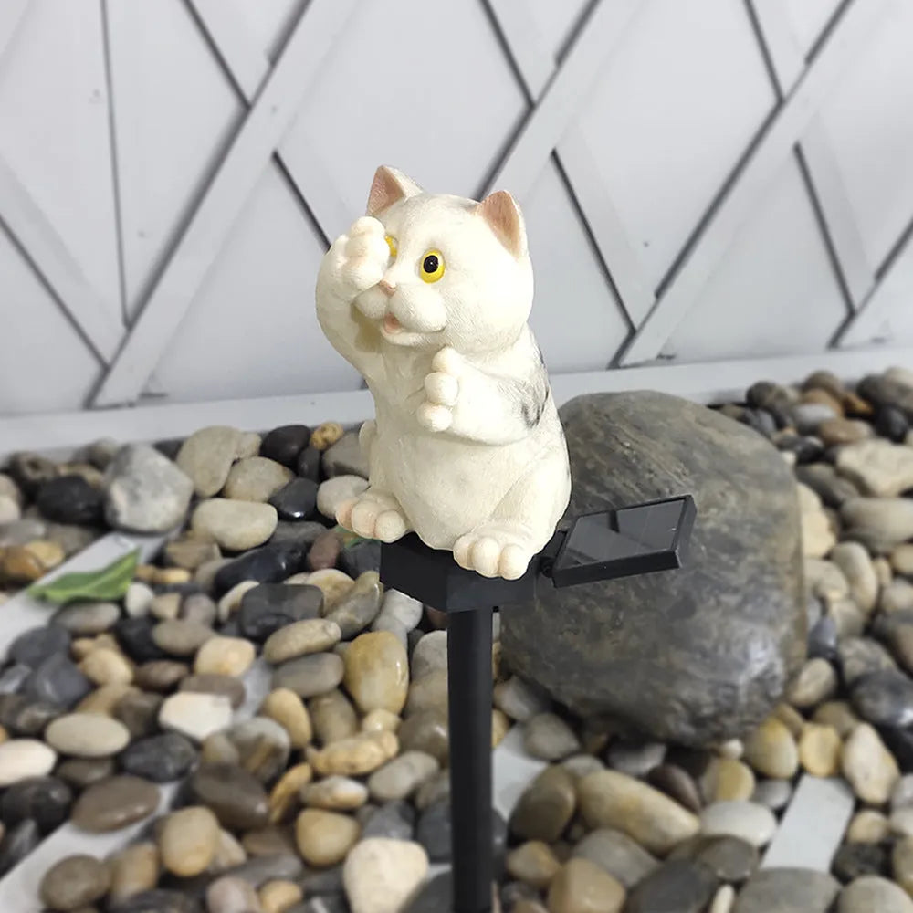 Brown cat-shaped solar lawn light in garden setting with LED illumination at dusk