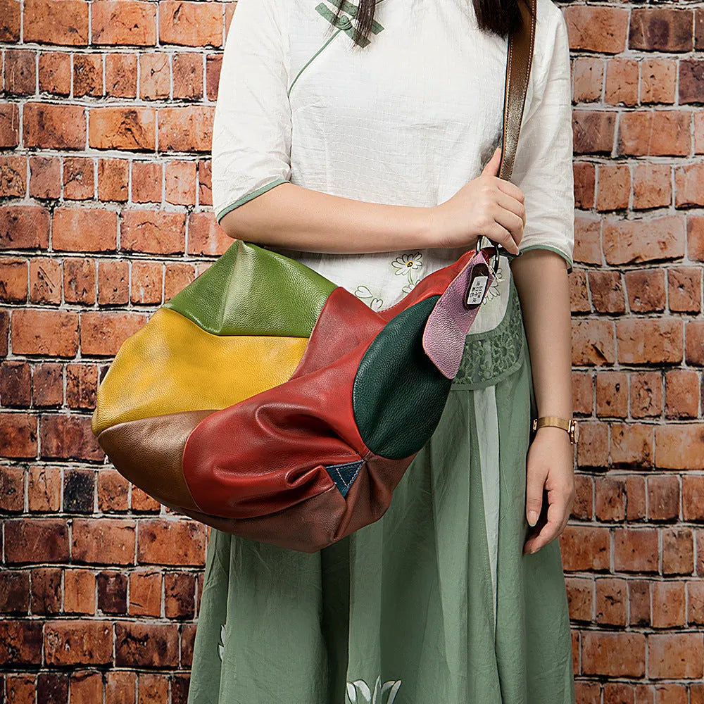 Brown cowhide leather travel crossbody shoulder bag with stitching detail, shown with a laptop and A4 magazine.