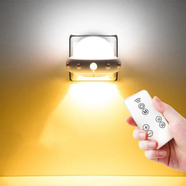 Remote control UFO shaped bedside night light in blue, pink or white colours on a table