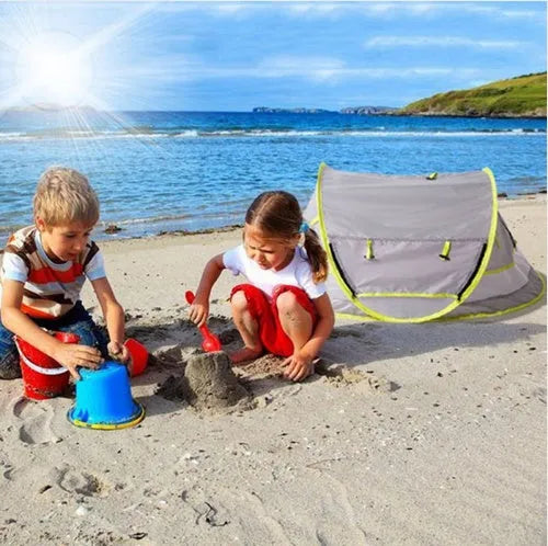 Grey children's beach tent with fiberglass frame and Oxford cloth outer, set up on sand
