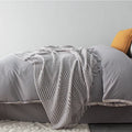 Small light grey polyester nap blanket laid flat showing 127x170cm size.