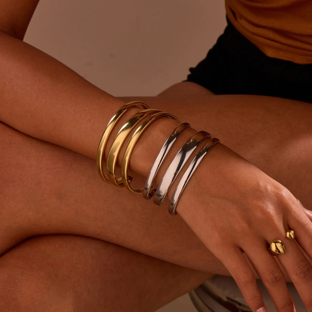 Women's stainless steel simple opening bracelet with geometric line design in gold or steel colour.